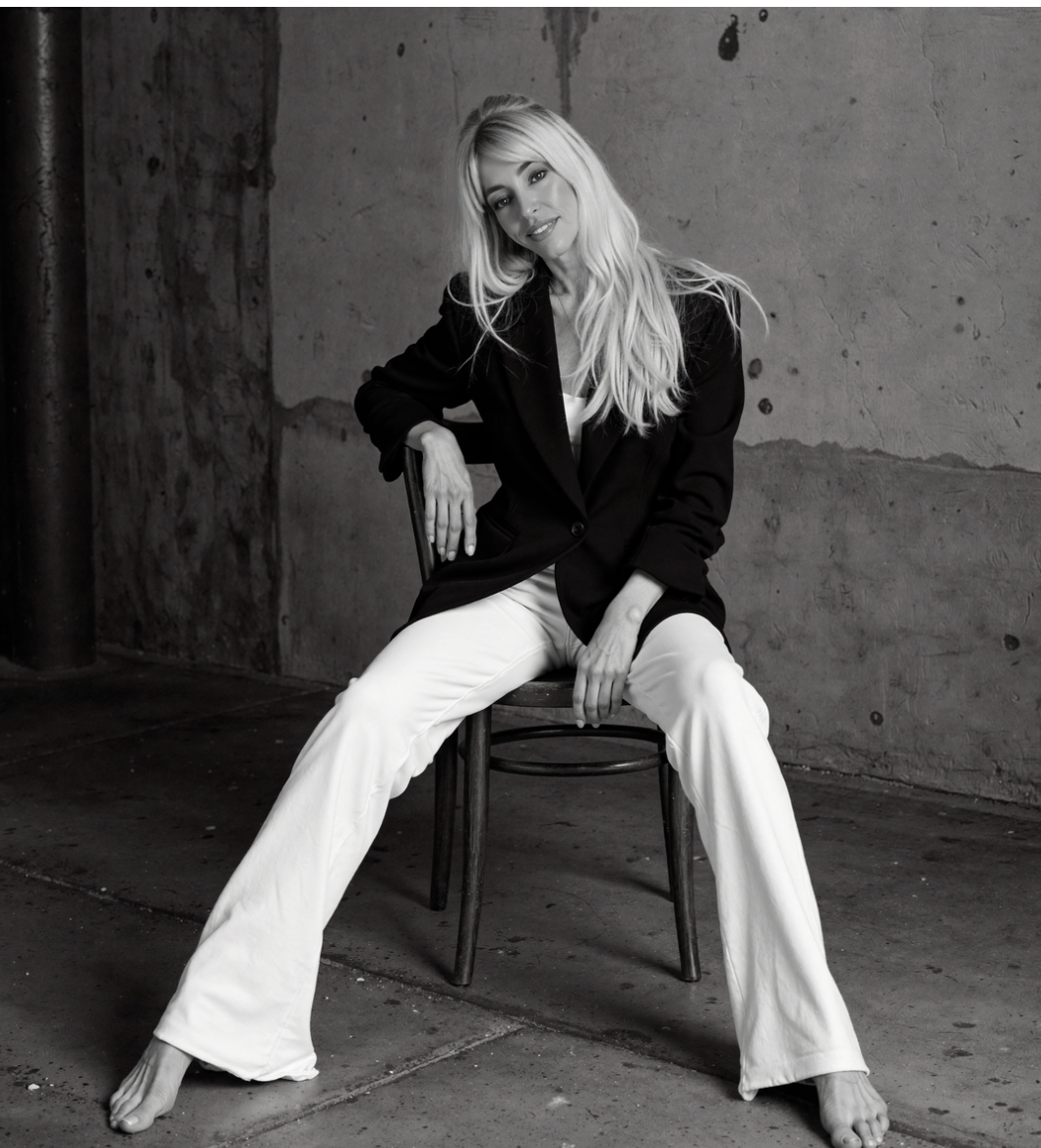 Liana Shanti seated confidently in a black-and-white editorial portrait